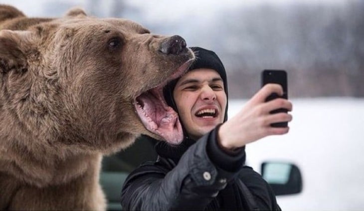 selfie con oso grizzly en la nieve