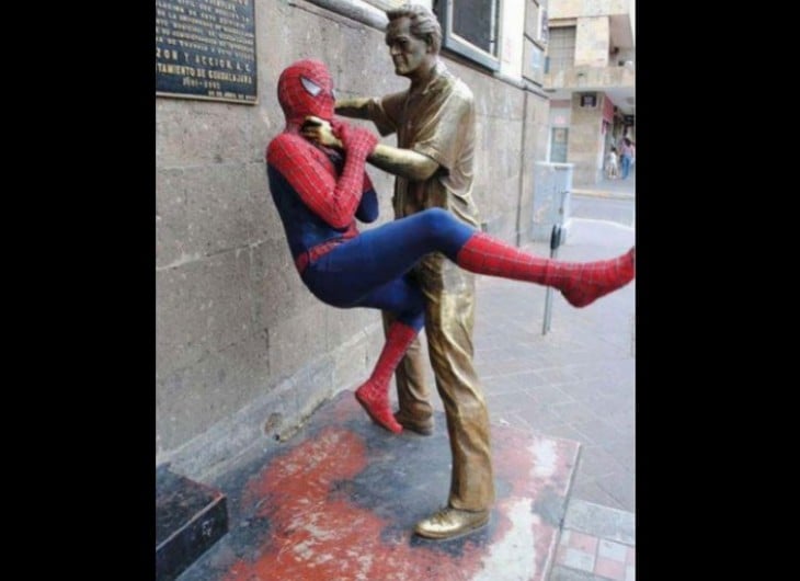 estatua maltratando a spiderman