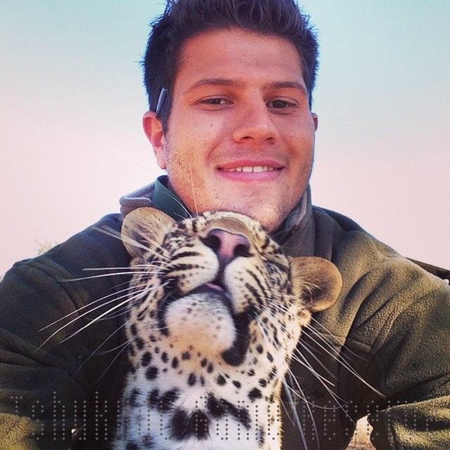 hombre se toma selfie con cachorro de leopardo