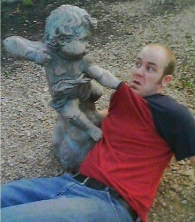 estatua de niño golpeando a hombre