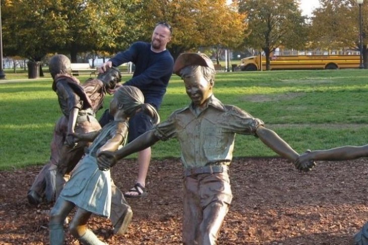 hombre pateando estatua de niños