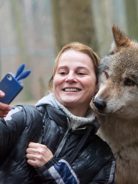 mujer toma selfie con su celular con un lobo