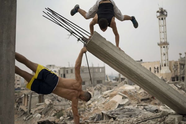 Bakr al-Makadmeh bandera y parados de manos en las ruinas de palestina