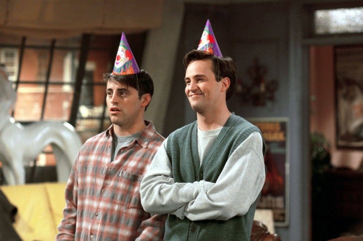 Chandler y Joey con gorros de fiesta