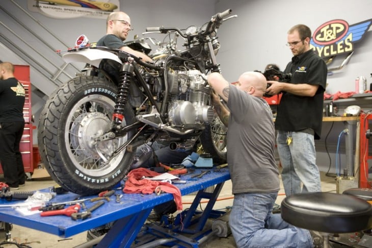 hombres reparando motocicletas