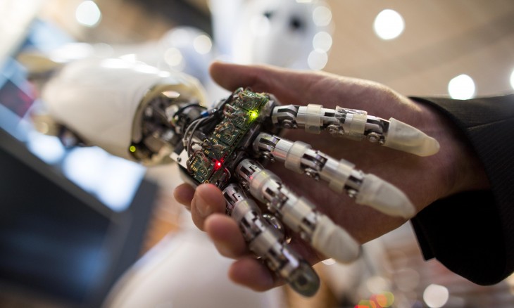 mano de robot saludando mano humana