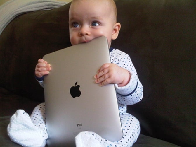 bebe masticando una laptop