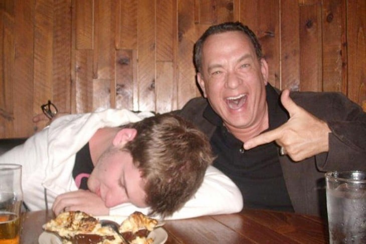 tom hanks en un bar tomandose foto con un borracho dormido 