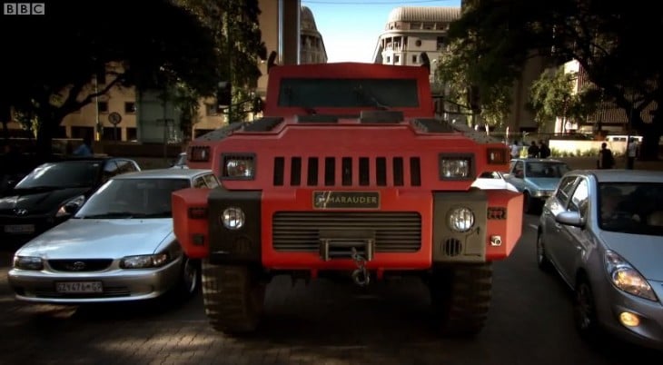 marauder rojo en la calle con autos de civiles