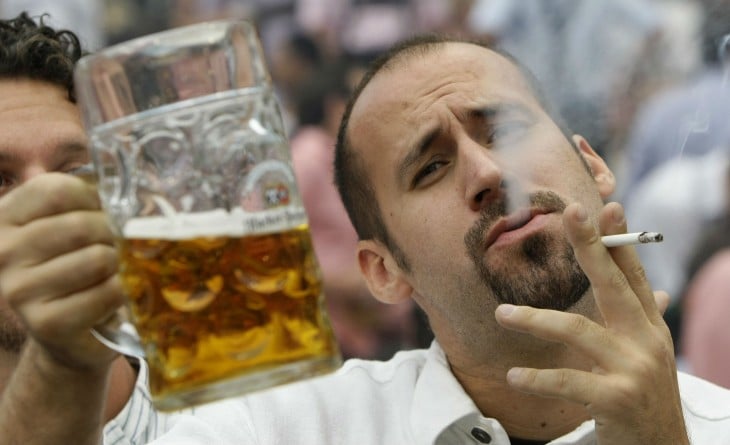 hombre fufmando y bebiendo cerveza