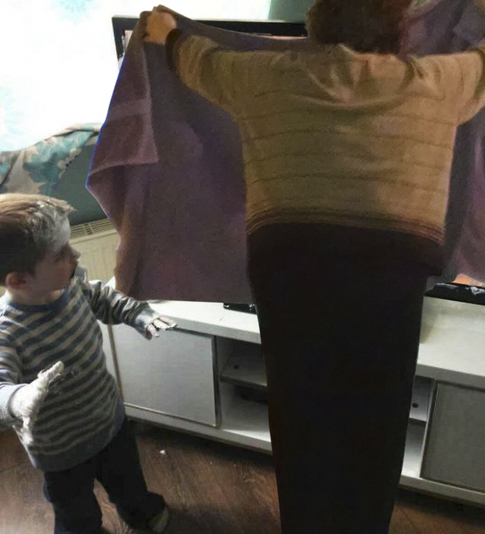 abuelita tapando travesura de Niño que mancha pantalla de televisor