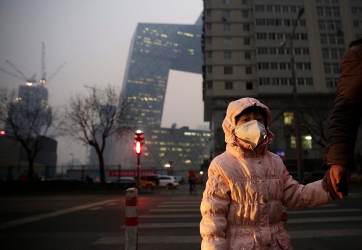 Niña china usa cubrebocas ante alta contaminación