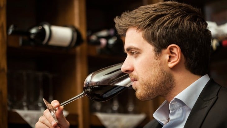 Hombre tomando una copa de vino tinto 