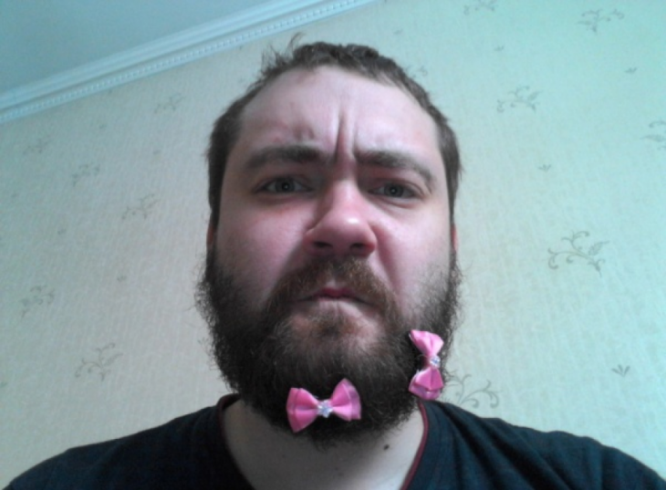 Hombre con broches en color rosa sobre su barba 