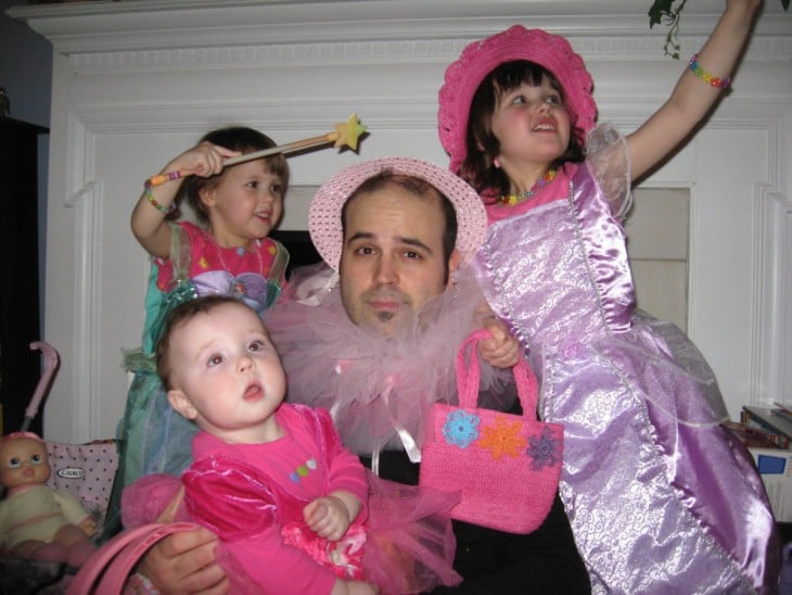 hombre rodeado de sus hijas con un sombrero de color rosa 