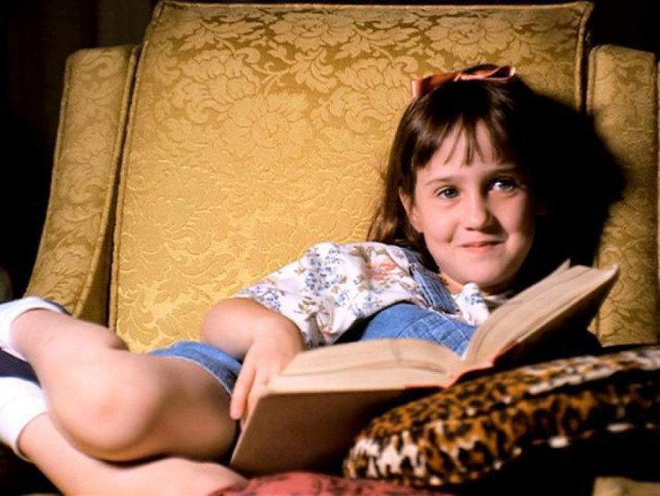 Actriz de la película Matilda leyendo en sofá