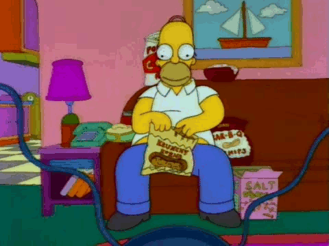 Homero en el sofá comiendo botanas