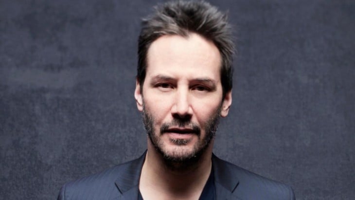 Keanu Reeves con saco negro y pelo corto