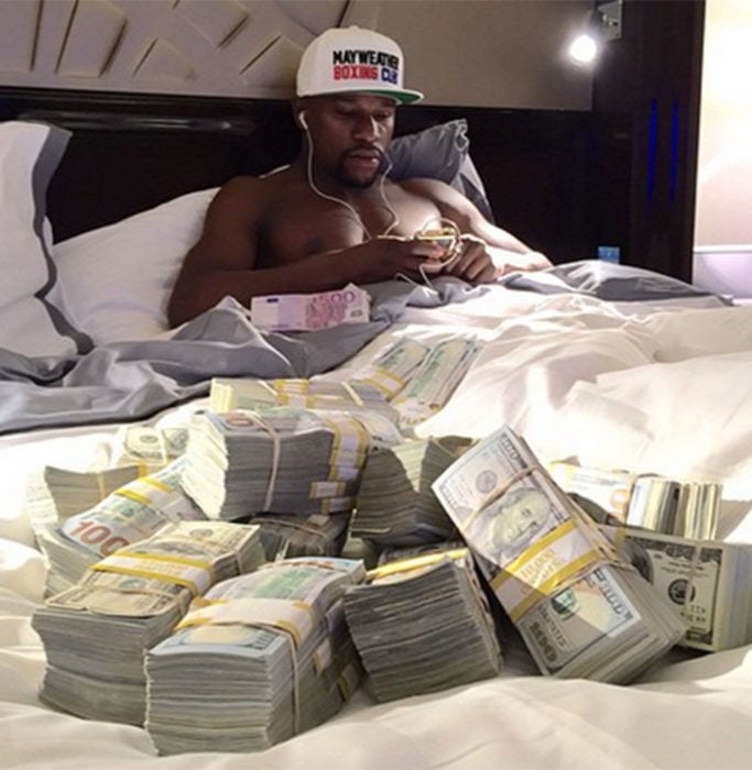 Floyd Mayweather en cama con billetes