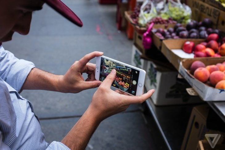 hombre tomando foto de frutas con iphone