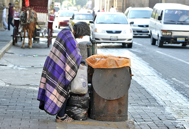 Hombre busca en la basura