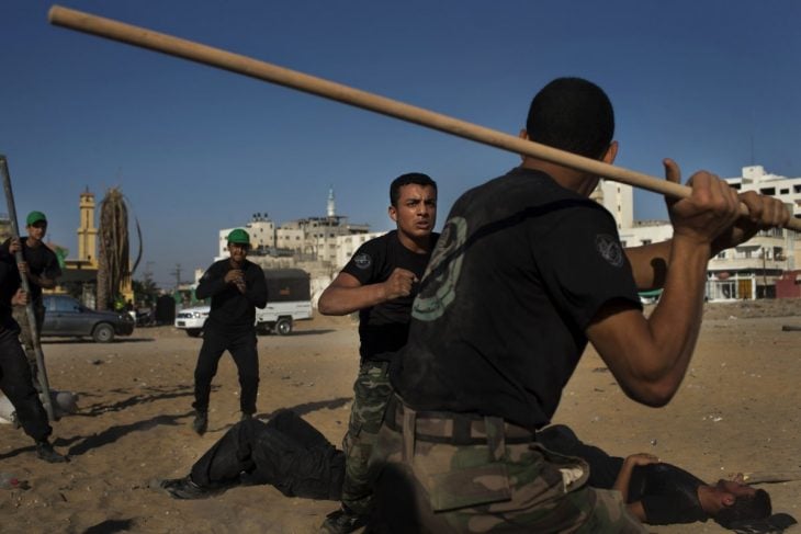 hombres pelando con un palo