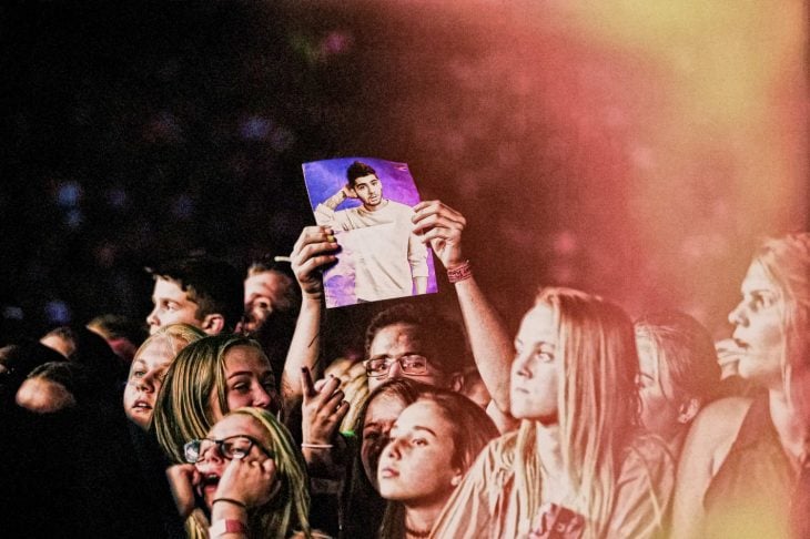 Hombre sosteniendo cartel en concierto de 1D