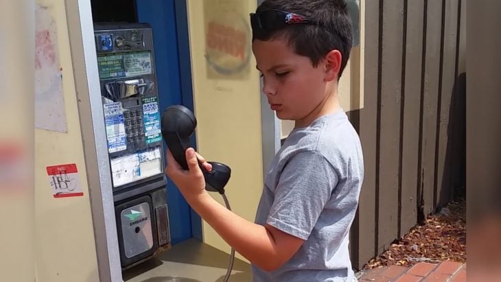 Niño confundido con teléfono de monedas