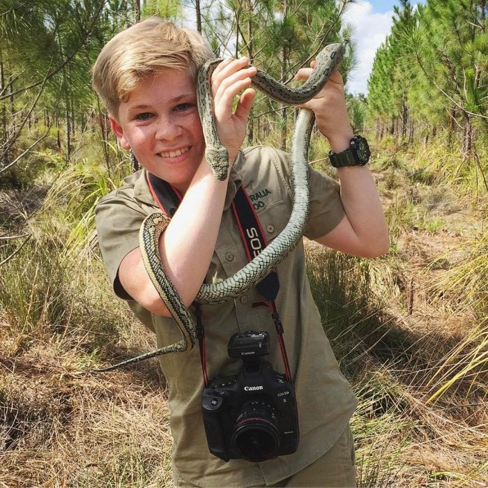 Niño sostiene una serpiente