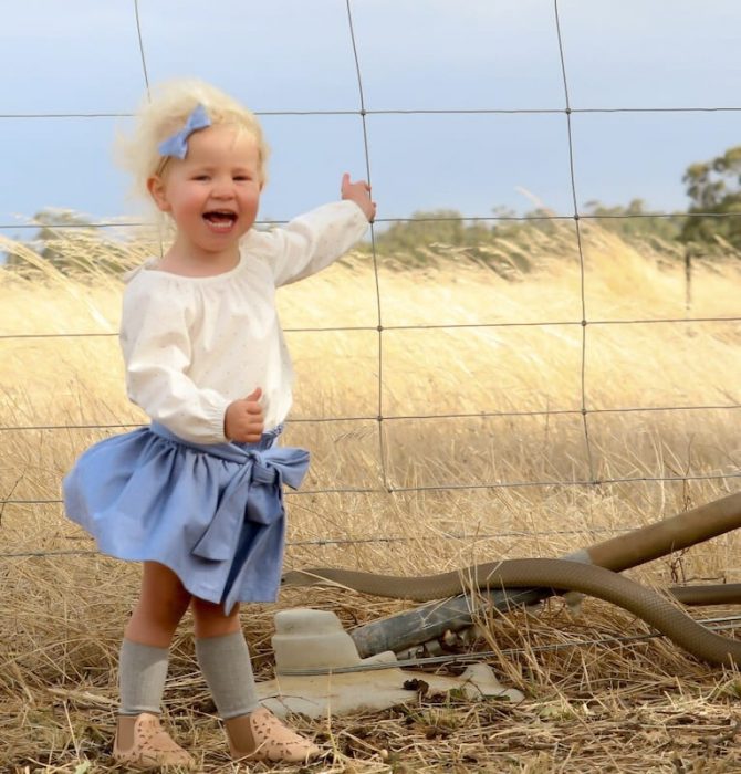 Niña en el campo con serpiente