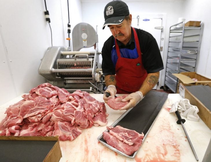 carnicero cortando carne