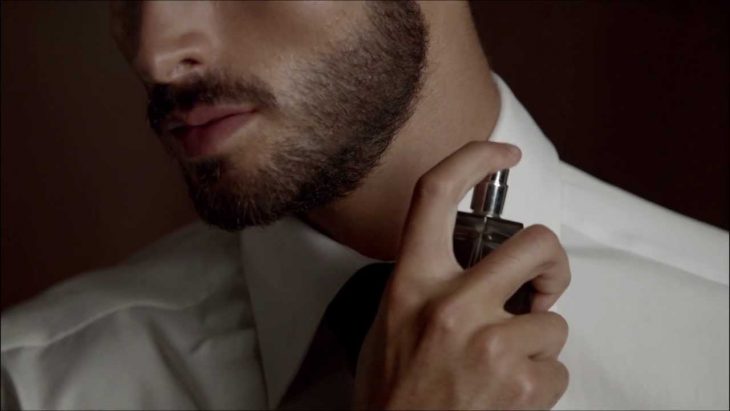 hombre aplica perfume