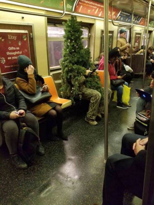 gente extraña metro arból navidad