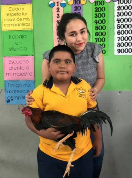 Maestra, niño y gallo