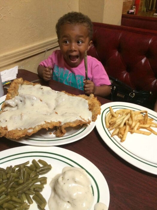 Niño con una milanesa