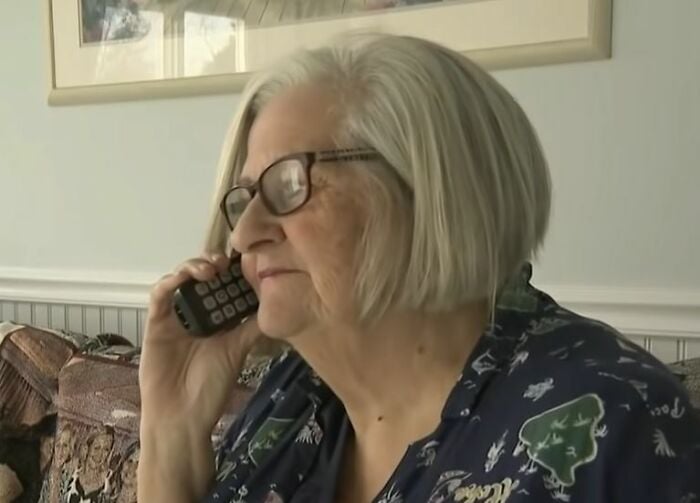 Abuela Jean, hablando por teléfono, se relame los labios pensando en la presa que va a cazar
