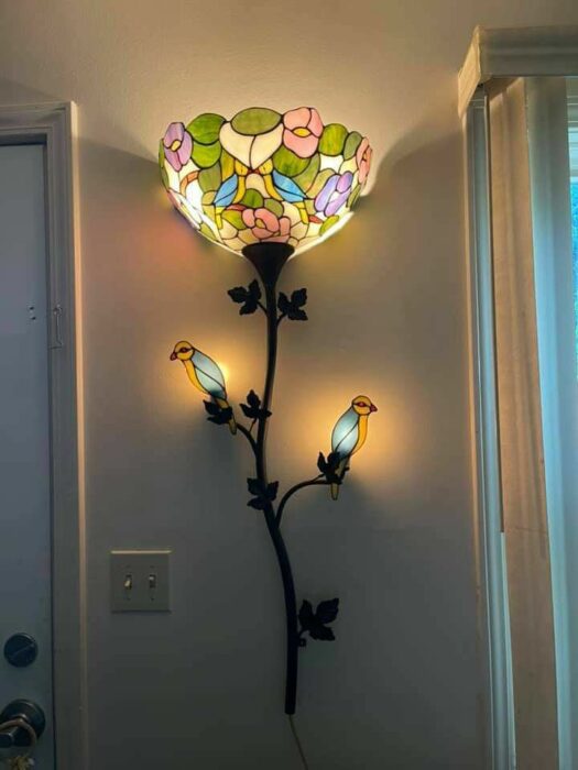 lampara en forma de flor con dos pájaros en la parte inferior sobre una pared 