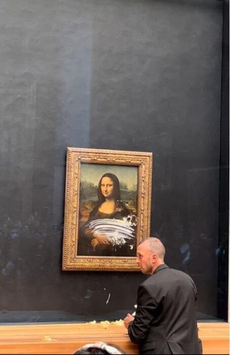 La Gioconda siendo limpiado su vidrio de seguridad