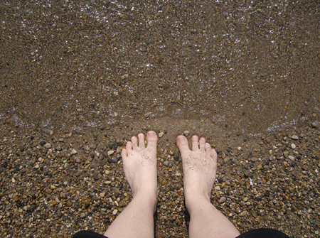 día en la playa pies y oleaje