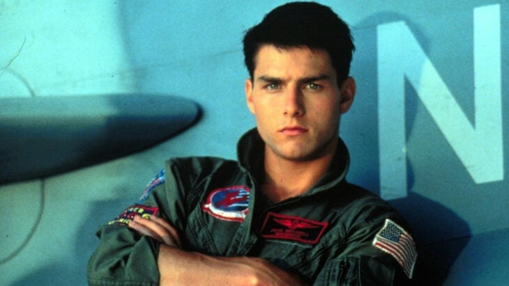 Tom Cruise en la Top Gun original con los brazos cruzado y en uniforme de aviador