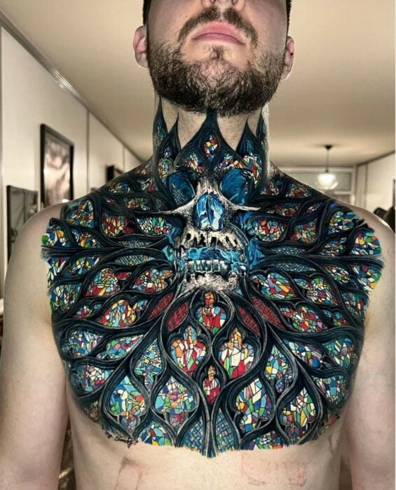 Tatuaje que imita a un vitral en el pecho de un hombre con una clavera