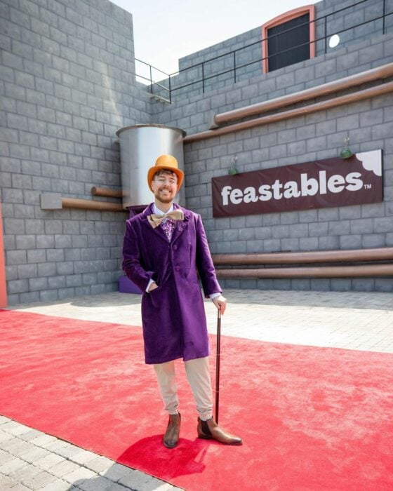Mr Beast posando vestido como Willy Wonka frente a su marca FReastables sobre una alfombra roja Jimmy Donaldson