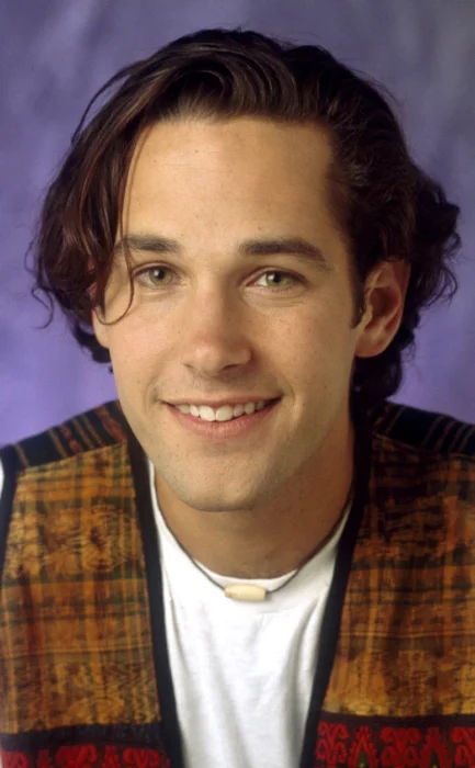 Paul Rudd de joven sonriendo camisa blanca cadena