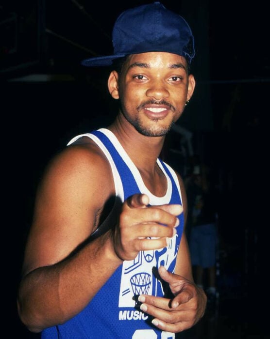 Will smith joven en uniforme azul de basquetbol y con gorra azul señalando