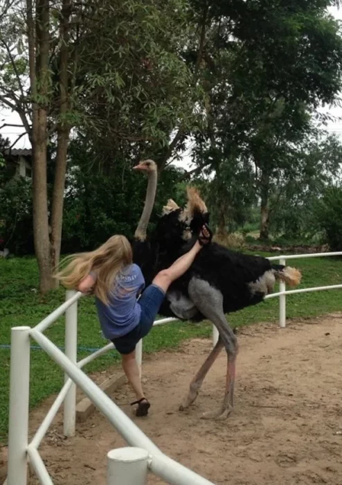 Patada de avestruz una muchacha levantando la pierna como para moontar a una avestruz