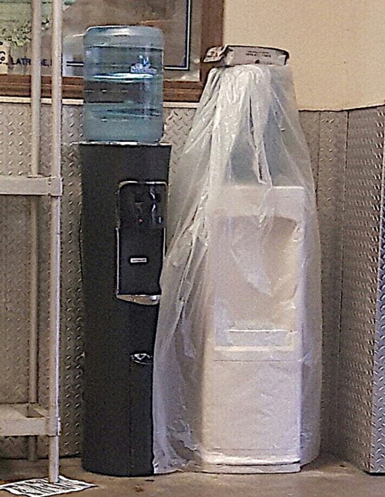 Dos dispensadores de garraqfones de agua que parecen a punto de casarse