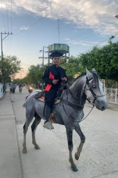 chico sobre caballo recibiendo título graduación