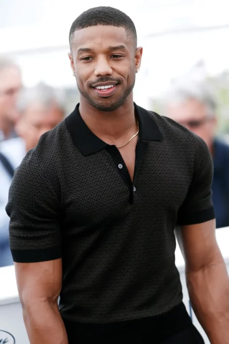 Michael B jordan en camisa negra sonriendo