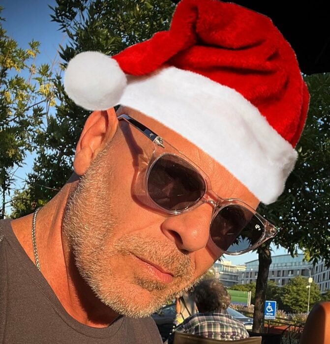 Bruce Willis con un photoshop de una gorra navideña y con lentes oscuros