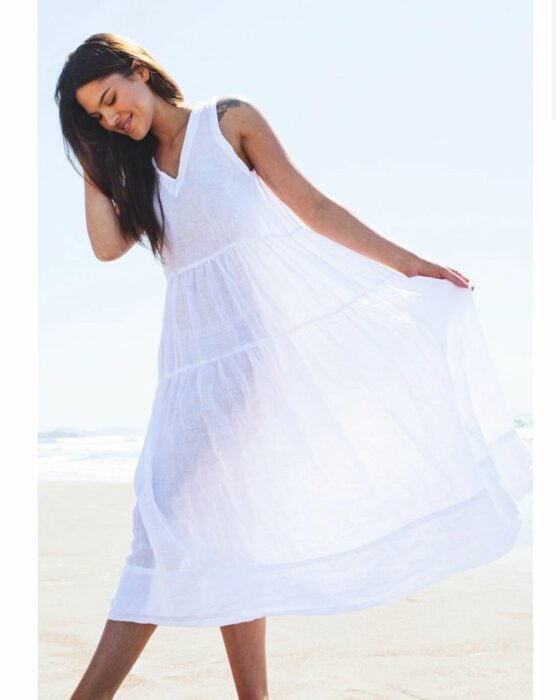 Emily Adonna en vestido blanco en la playa